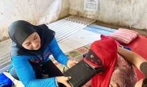 Petugas program Gladiator Hulubalang atau Gelar Layanan Adminduk di Atas Motor Khusus Layani untuk Bantu Masyarakat Wilayah Palembang, melakukan perekaman data KTP warga. Foto: Kominfo Palembang.