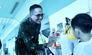 Walikota Palembang Drs H Ratu Dewa membagikan souvenir kepada para penumpang Garuda Indonesia, Kamis (4/9/2025). Foto: Kominfo Palembang.