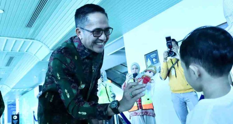 Walikota Palembang Drs H Ratu Dewa membagikan souvenir kepada para penumpang Garuda Indonesia, Kamis (4/9/2025). Foto: Kominfo Palembang.