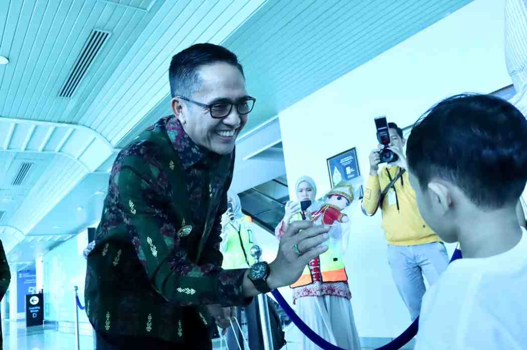Walikota Palembang Drs H Ratu Dewa membagikan souvenir kepada para penumpang Garuda Indonesia, Kamis (4/9/2025). Foto: Kominfo Palembang.