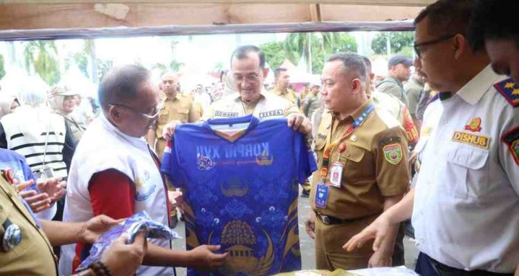 Sekda Sumsel, Edward Candra melihat baju kaos yang dijual di bazar Pornas Korprci di halaman DPRD Sumsel, Rabu (8/10/2025). Foto: Humas Pemprov Sumsel.