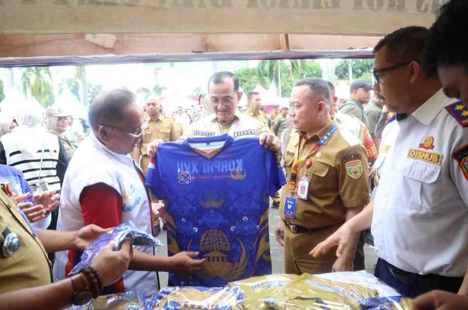 Sekda Sumsel, Edward Candra melihat baju kaos yang dijual di bazar Pornas Korprci di halaman DPRD Sumsel, Rabu (8/10/2025). Foto: Humas Pemprov Sumsel.