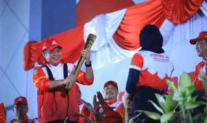 Gubernur Sumsel, Herman Deru membawa obor saat pembukaan Porprov Muba, Sabtu (18/10/2025) malam. Foto: Humas Pemprov Sumsel.
