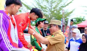 Bupati Muba, HM Toha mengalungkan medali emas pada atlet penerima medali emas panjat tebing Porprov, Selasa (21/10/2025). Foto: Kominfo Muba.