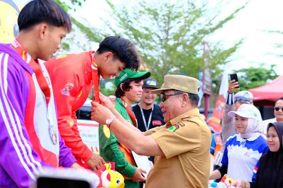Bupati Muba, HM Toha mengalungkan medali emas pada atlet penerima medali emas panjat tebing Porprov, Selasa (21/10/2025). Foto: Kominfo Muba.