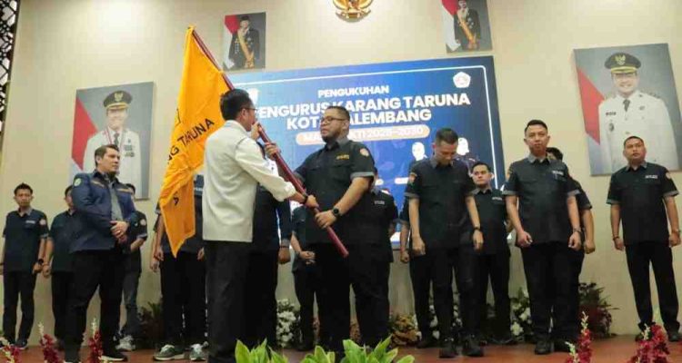 Walikota Palembang, Ratu Dewa menyerahkan bendara Karang Taruna kepada pengurus Karang Taruna yang baru dilantik, Selasa (28/10/2025). Foto: Kominfo Palembang.