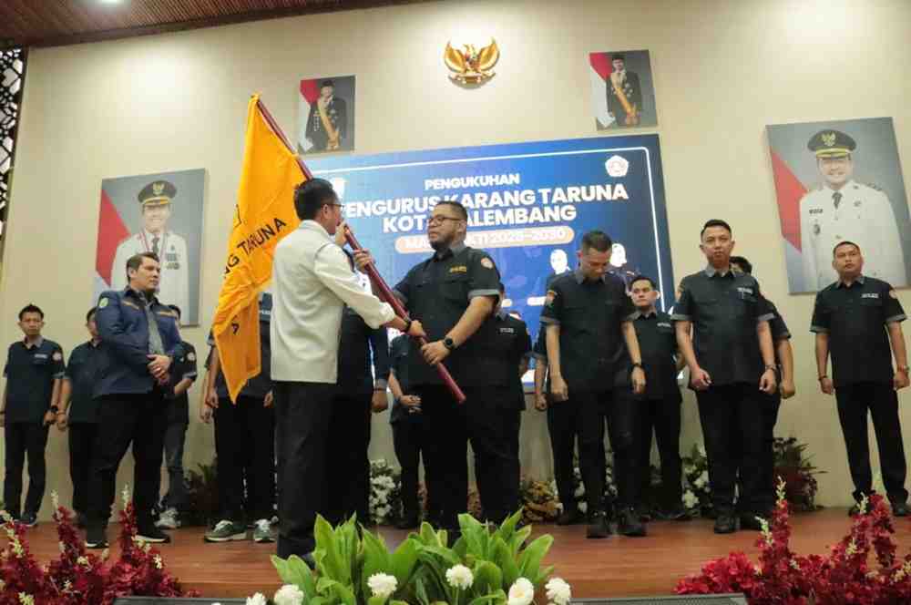Walikota Palembang, Ratu Dewa menyerahkan bendara Karang Taruna kepada pengurus Karang Taruna yang baru dilantik, Selasa (28/10/2025). Foto: Kominfo Palembang.