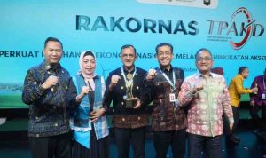 Sekda Sumsel, Edward Candra menerima piala Sumsel sebagai Provinsi Terbaik TPAKD Award 2025 tingkat wilayah Sumatera oleh OJK RI, Jumat (10/10/2025). Foto: Humas Pemprov Sumsel.