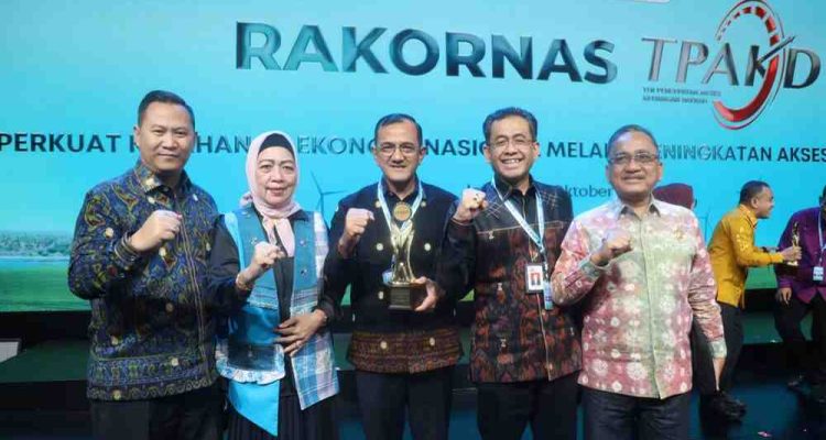 Sekda Sumsel, Edward Candra menerima piala Sumsel sebagai Provinsi Terbaik TPAKD Award 2025 tingkat wilayah Sumatera oleh OJK RI, Jumat (10/10/2025). Foto: Humas Pemprov Sumsel.