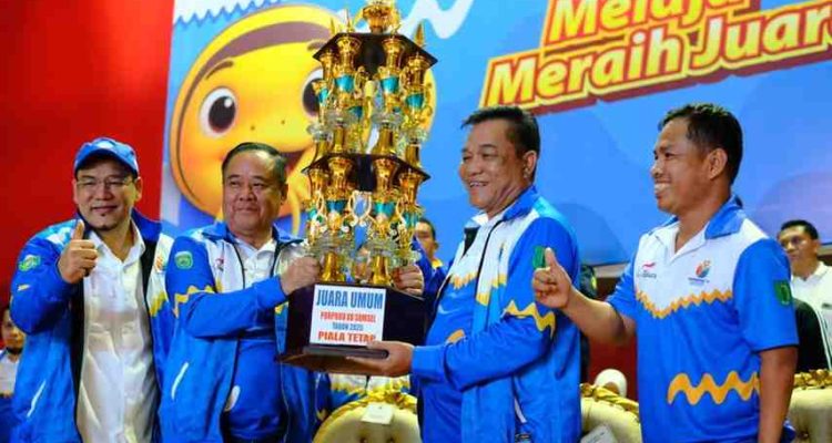 Bupati Muba, HM Toha menerima piala bergilir juara umum Porprov Sumsel dari Wagub Sumsel, Cik Ujang, Sabtu (1/11/2025) malam. Fotot: Kominfo Muba.
