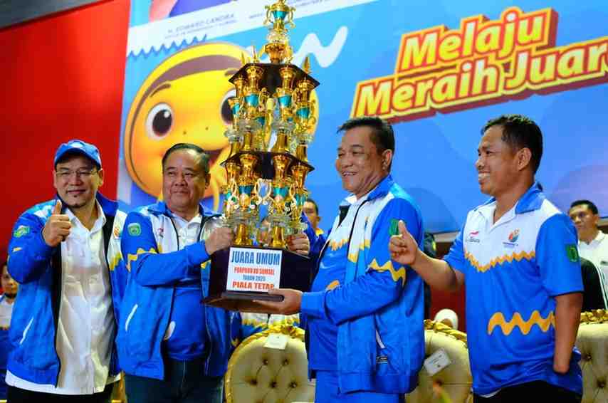 Bupati Muba, HM Toha menerima piala bergilir juara umum Porprov Sumsel dari Wagub Sumsel, Cik Ujang, Sabtu (1/11/2025) malam. Fotot: Kominfo Muba.