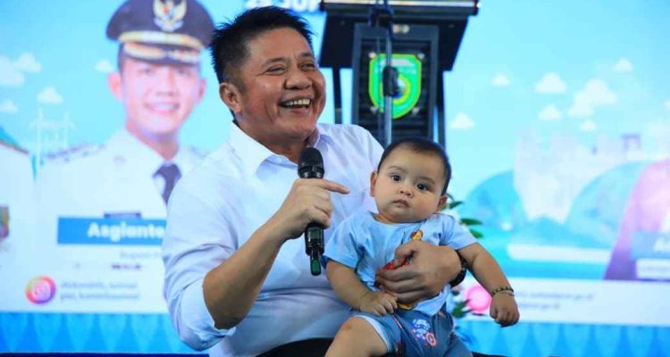 Gubernur Sumsel, Herman Deru bersama seorang bayi sehat di sebuah acara. Foto: Dok Humas Pemprov Sumsel.