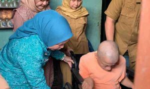 Ketua PKK Palembang, Dewi menyerahkan bantuan kursi roda kepada Salim, warga Kemas Rindo, Senin (8/12/2025). Foto: Kominfo Palembang.