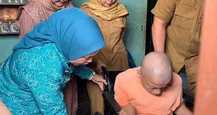 Ketua PKK Palembang, Dewi menyerahkan bantuan kursi roda kepada Salim, warga Kemas Rindo, Senin (8/12/2025). Foto: Kominfo Palembang.