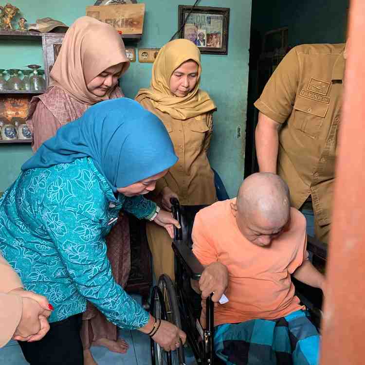 Ketua PKK Palembang, Dewi menyerahkan bantuan kursi roda kepada Salim, warga Kemas Rindo, Senin (8/12/2025). Foto: Kominfo Palembang.
