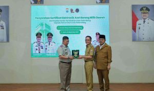 Walikota Palembang, Ratu Dewa didampingi Wawako Prima Salam secara simbolis menerima sertifikat elektronik ataa aset daerah dari BPN, Senin (29/12/2025). Foto: Kominfo Palembang.