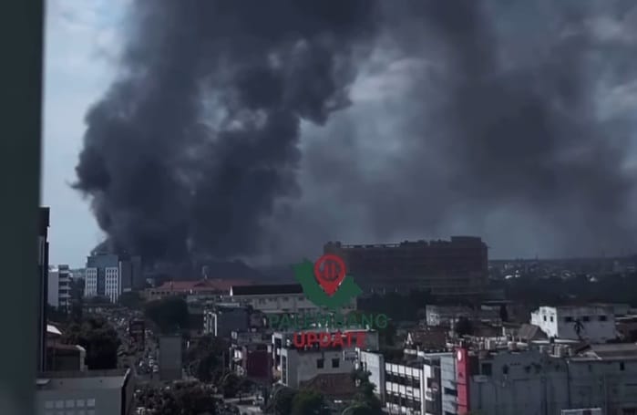 Asap tebal membumbung dari kebakaran gudang ban di Kemuning, Palembang, Senin (23/3/2026) dini hari. Foto: screenshot medsos.