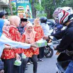 Kadiskominfo Palembvang, Adi Zahri mendampingi Ketua Dharma Wanita Persatuan Dinas Kominfo Kota Palembang membagi takjil kepada sejumlah pengendara. Foto: Kominfo Palembang.