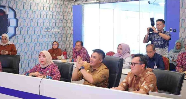 Sekretaris Daerah Kota Palembang, Aprizal Hasyim mengikuti rapat koordinasi melalui video conference (Vidcon) terkait Asistensi dan Monitoring serta Evaluasi (Monev) Pelaksanaan Program Percepatan Capaian Universal Coverage Jaminan Sosial Ketenagakerjaan (UCJ) Tahun 2026, Kamis (23/4/2026) di Lawang Jabo Command Center. Foto: Kominfo Palembang.