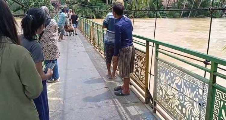 Sebuah jembatan gantung nyarus terendam di Muratara. Foto: IST