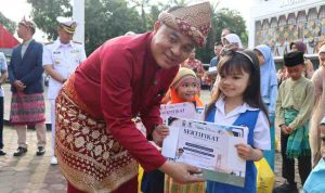 Sekda Palembang, Aprizal Hasyim menyerahkan sertifikat pada anak TK usai upacara Hardiknas, Sabtu (2/5/2026). Foto: Kominfo Palembang.