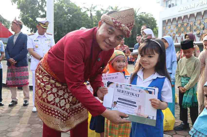 Sekda Palembang, Aprizal Hasyim menyerahkan sertifikat pada anak TK usai upacara Hardiknas, Sabtu (2/5/2026). Foto: Kominfo Palembang.