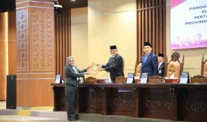 Sekda Sumsel, Edward Chandra menerima berkas pandangan fraksi terhadap LPJ Gubernur Sumsel akan pelaksanaan APBD Sumsel 2025 pada rapat paripurna DPRD Sumsel, Jumat (26/6/2026). Foto: Humas Pemprov Sumsel.