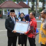 Sekda Sumsel, Edward Candra memberikan penghargaan pada saat apel gabungan Hari Koperasi Nasional yang digelar di Halaman Kantor Gubernur Sumatera Selatan, Senin (20/7/2026). Foto: Humas Pemprov Sumsel.