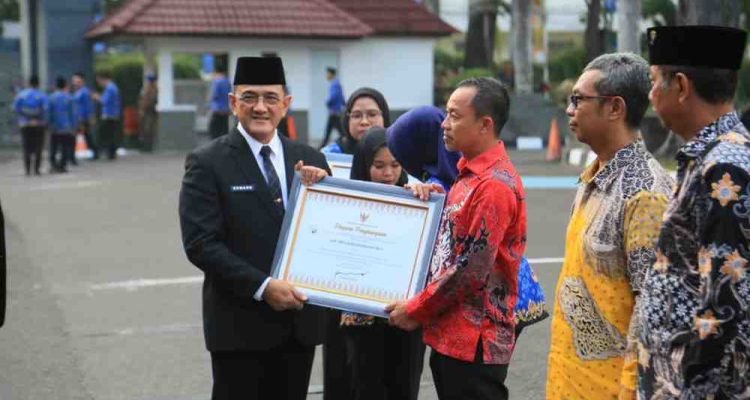 Sekda Sumsel, Edward Candra memberikan penghargaan pada saat apel gabungan Hari Koperasi Nasional yang digelar di Halaman Kantor Gubernur Sumatera Selatan, Senin (20/7/2026). Foto: Humas Pemprov Sumsel.