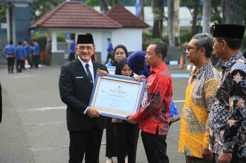 Sekda Sumsel, Edward Candra memberikan penghargaan pada saat apel gabungan Hari Koperasi Nasional yang digelar di Halaman Kantor Gubernur Sumatera Selatan, Senin (20/7/2026). Foto: Humas Pemprov Sumsel.