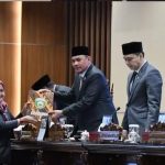Pimpinan rapat paripurna menerima berkas laporan hasil reses dari salah satu Dapil. Foto: Humas DPRD Sumsel.