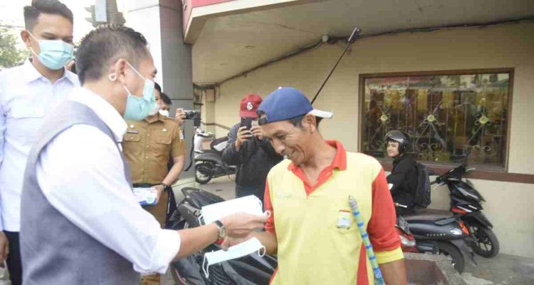 Walikota Palembang, Rayu Dewa sevcara simbolis membagikan masker ke warga. antisipasi kabut asap yang mulai menyelimuti Kota Palembang, Senin (24/8/2026). Foto: Kominfo Palembang.
