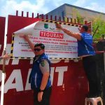 Petugas memasang stiker pada reklame yang tak bayar pajak. Foto: Kominfo Muba.