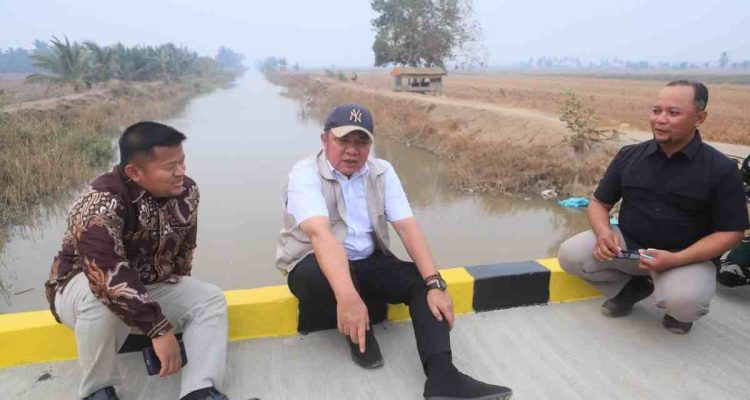 Gubernur Sumsel, Herman Deru beristirahat di atas jembatan saat berkunjung ke Muara Telang, Banyuasin. Foto: Humas Pemprov Sumsel.