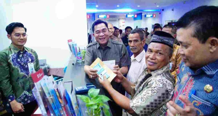 Bupati Muba HM Toha Tohet, SH, didampingi Sekda Muba Drs H Syafaruddin MSi, Pimpinan Bank Sumsel Babel Cabang Sekayu Irwan Antony SP, Plt Kadinsos Muba H. Deny SH MSi secara simbolis menyerahkan bantuan program keluarga maju di Bank Sumsel Babel Cabang Sekayu, Kamis (24/9/2026). Foto: Kominfo Muba.
