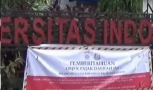 Spanduk tentang tunggakan bayar PBB di depan pagar IGM, Palembang. Foto: IST