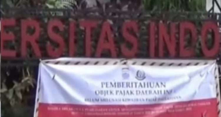 Spanduk tentang tunggakan bayar PBB di depan pagar IGM, Palembang. Foto: IST