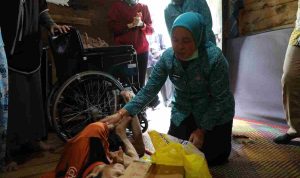 Ketua Tim Penggerak (TP) PKK Kota Palembang, Hj. Dewi Sastrani hadir langsung untuk menyerahkan bantuan kursi roda dan sembako pada warga 34 Ulu Palembang, Kamis (15/10/2026). Foto: Kominfo Palembang.