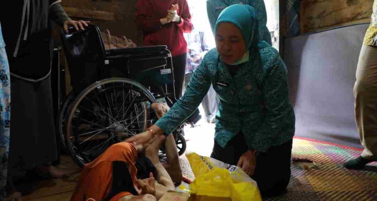Ketua Tim Penggerak (TP) PKK Kota Palembang, Hj. Dewi Sastrani hadir langsung untuk menyerahkan bantuan kursi roda dan sembako pada warga 34 Ulu Palembang, Kamis (15/10/2026). Foto: Kominfo Palembang.