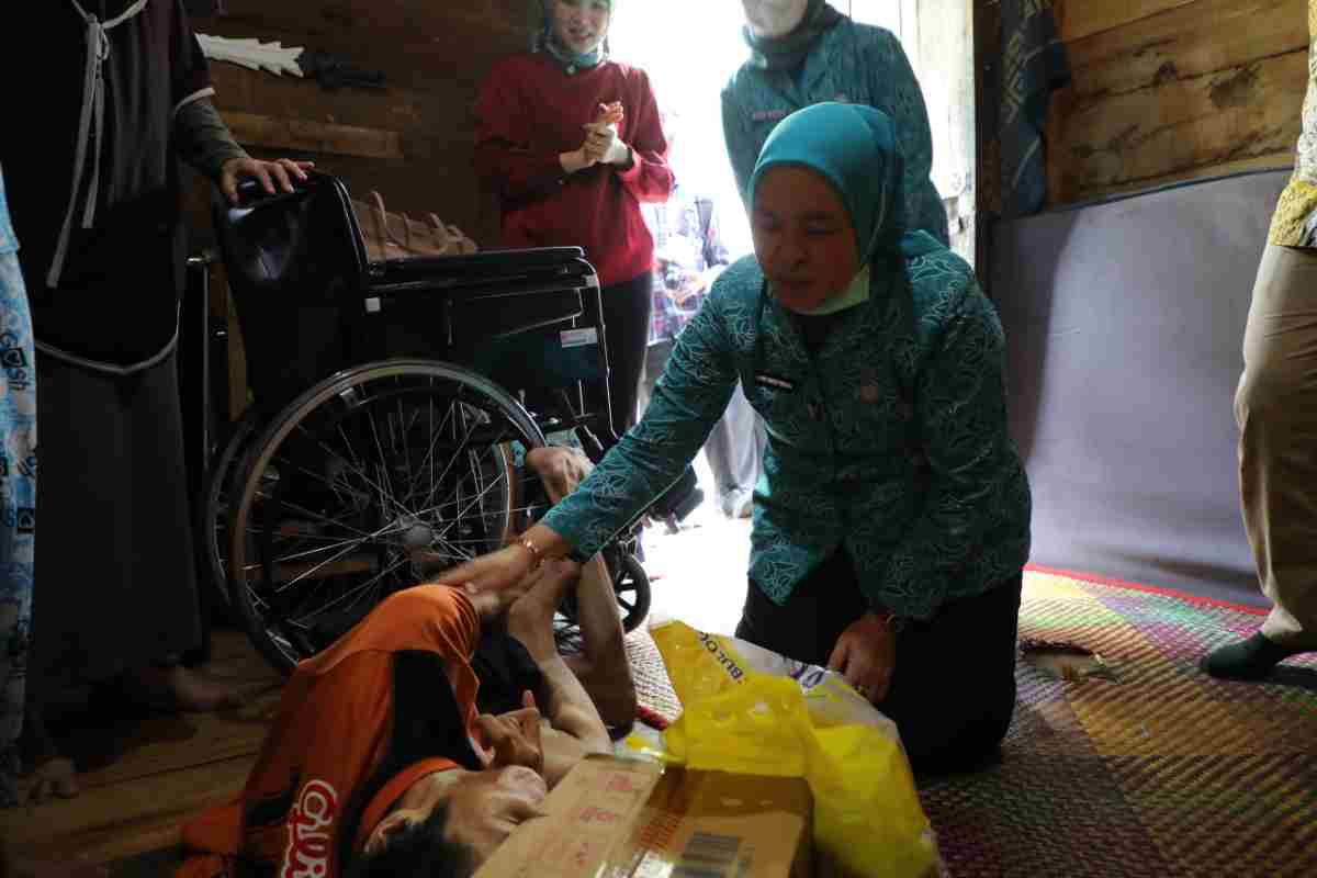 Ketua Tim Penggerak (TP) PKK Kota Palembang, Hj. Dewi Sastrani hadir langsung untuk menyerahkan bantuan kursi roda dan sembako pada warga 34 Ulu Palembang, Kamis (15/10/2026). Foto: Kominfo Palembang.