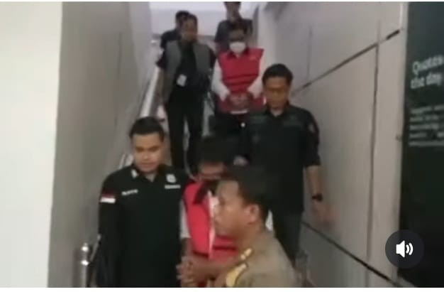 Kedua tersangka dalam kasus lampu jalan di Palembang saat digiring penyidik untuk menuju sel tahanan, Selasa (27/10/2026). Foto: IST/screenshot medsos.